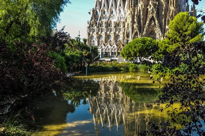 The Nativity facade of the Sagrada Familia reflected in the pond at Plaça de Gaudí